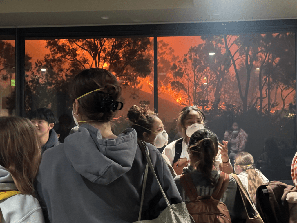 Pepperdine students gather around a window in Payson Library as the Franklin Fire reached campus Dec. 9. Students stayed up to date with news on the Franklin and Palisades fires through various platforms. Photo courtesy of Elizabeth Smith